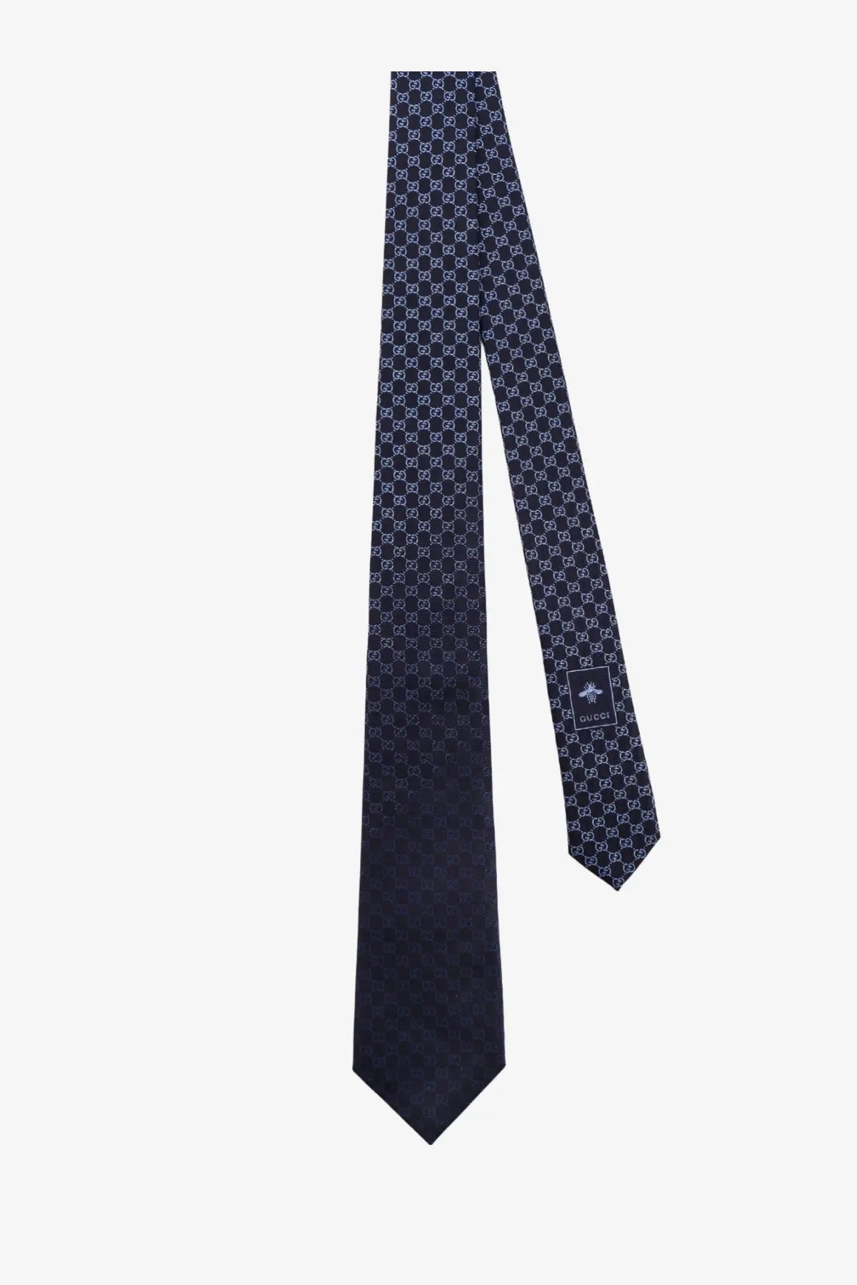 A navy blue Gucci men’s Shady silk tie featuring a repeating interlocking G monogram pattern in lighter tones