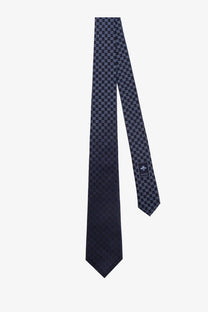 A navy blue Gucci men’s Shady silk tie featuring a repeating interlocking G monogram pattern in lighter tones