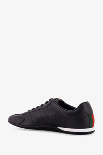 Black gucci mens shift leather sneakers showing back side with sleek leather upper and red green striped heel tab