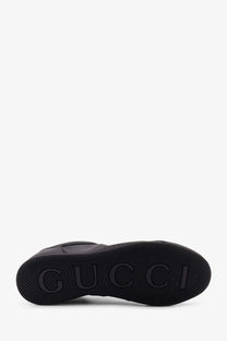Black Gucci men’s Gucci Shift leather sneaker with textured rubber sole and embossed logo visible on the side