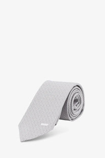 Gucci men’s silk tie white in light gray with a subtle repeating pattern and modern sleek design
