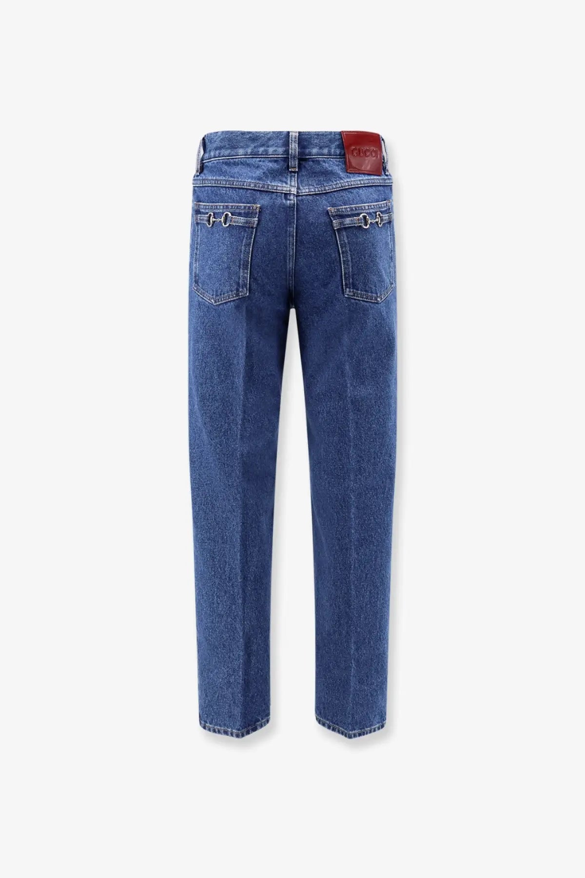Back side of gucci men’s slim blue denim jeans with red leather brand patch and metallic ring details on pockets