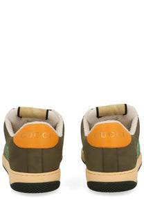Gucci men’s sneaker screener multicolor in olive green with orange heel tabs and beige rubber soles showing back side