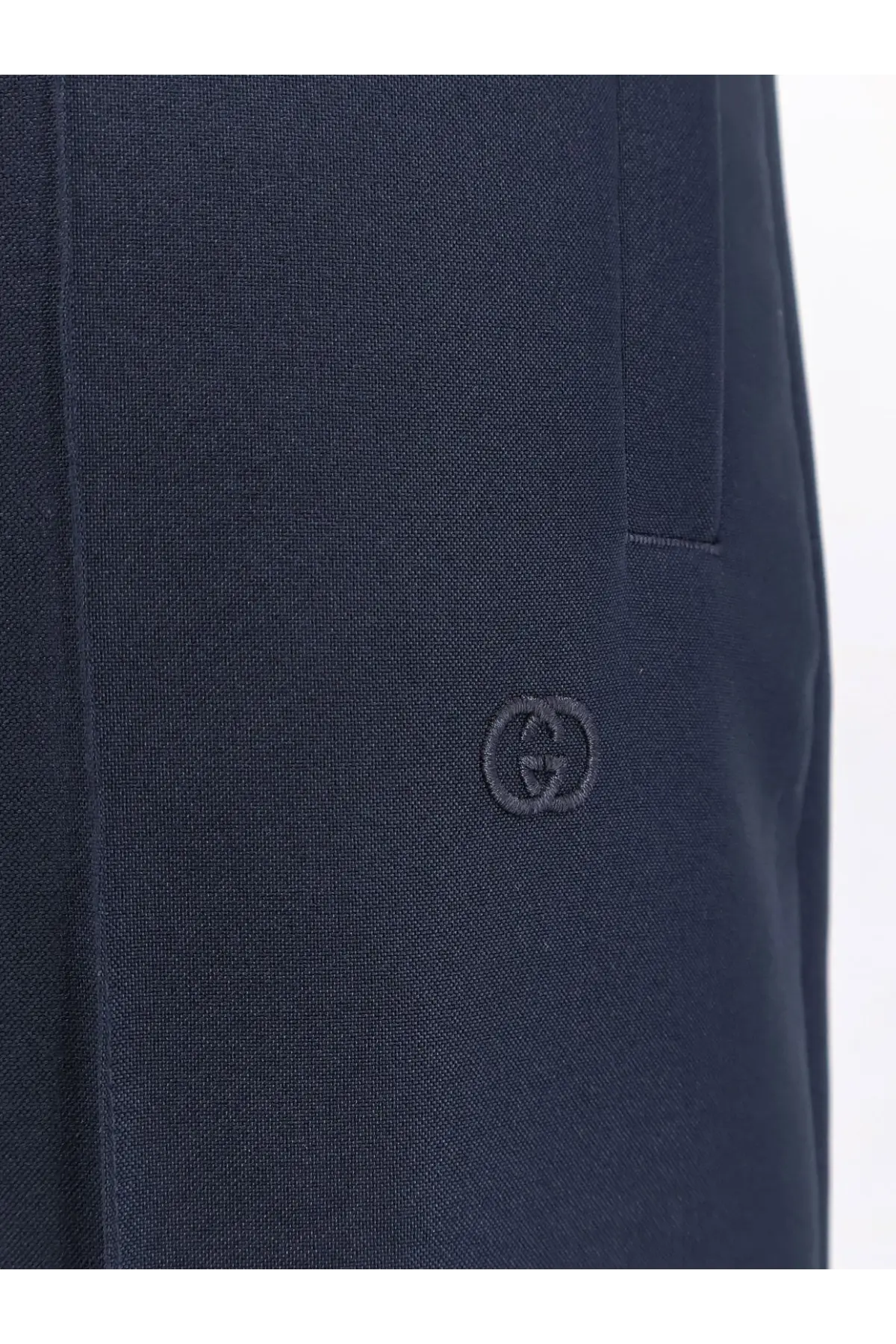 Dark blue textured fabric with subtle embroidered gucci logo on gucci men’s technical panama trousers black