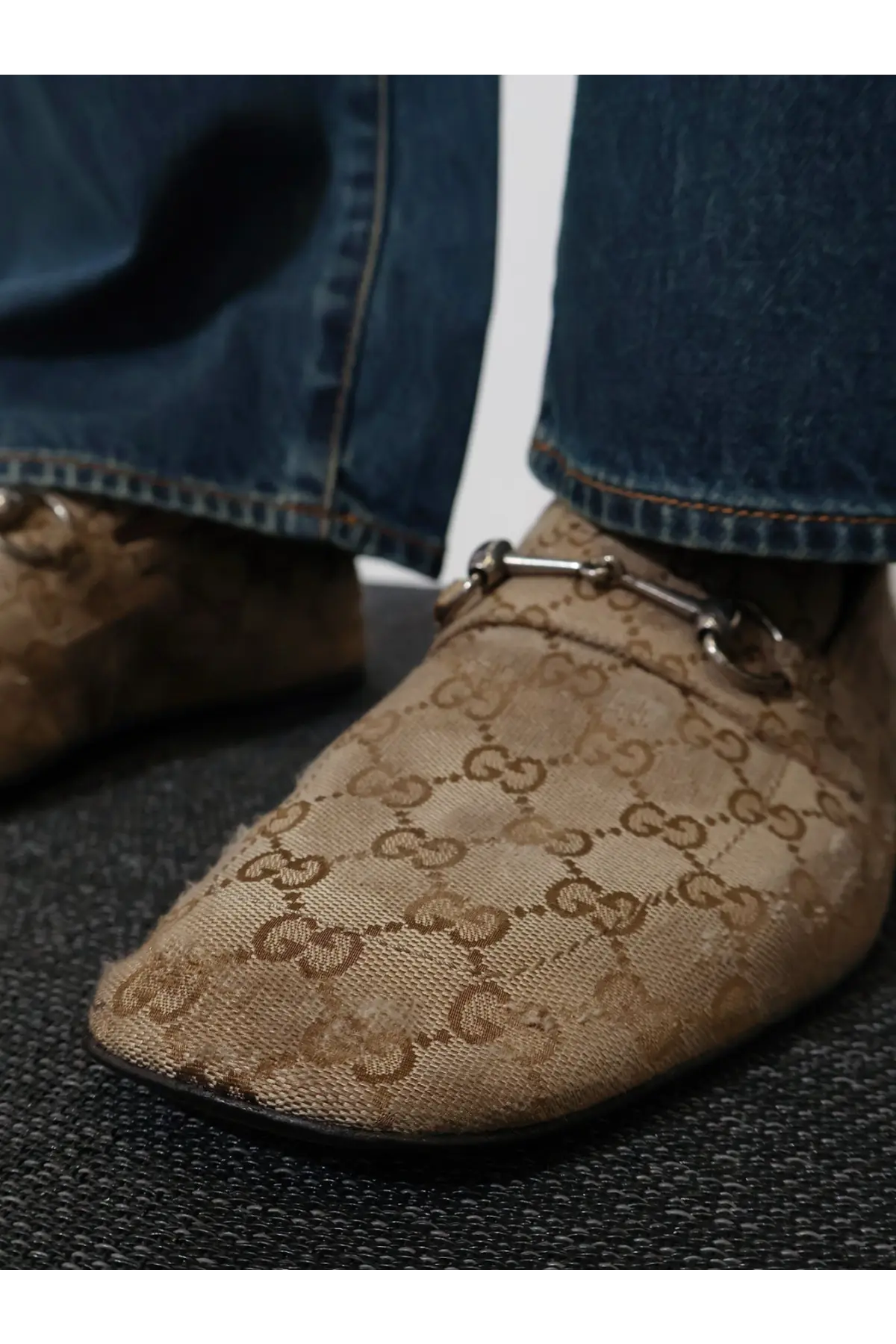 Beige Gucci men’s vintage effect loofers in GG fabric with repeating monogram and metallic horsebit detailing