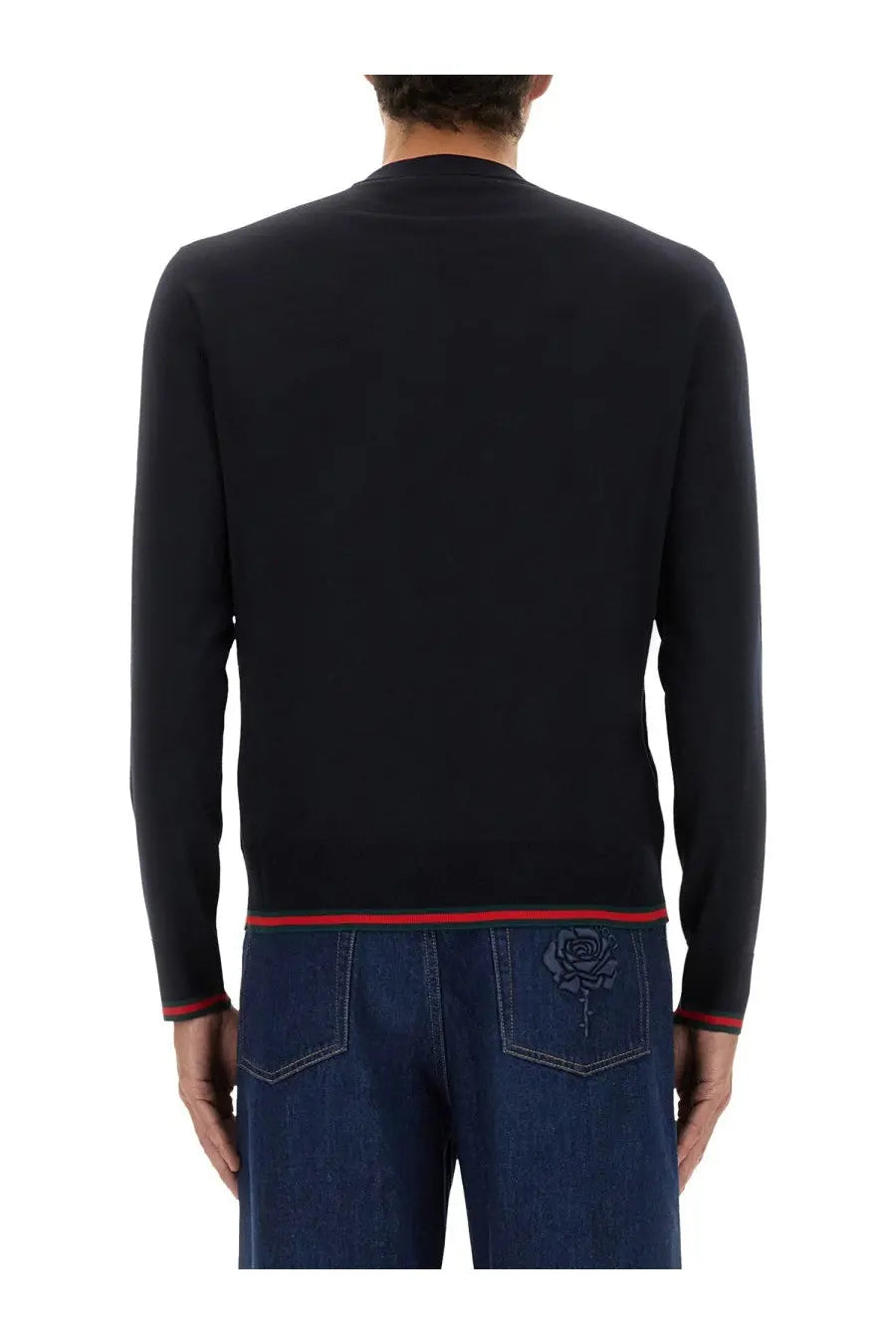 Back view of a black gucci sweater with red trim and rose embroidery on the back pocket from the gucci men’s web pattern sweater blue collection