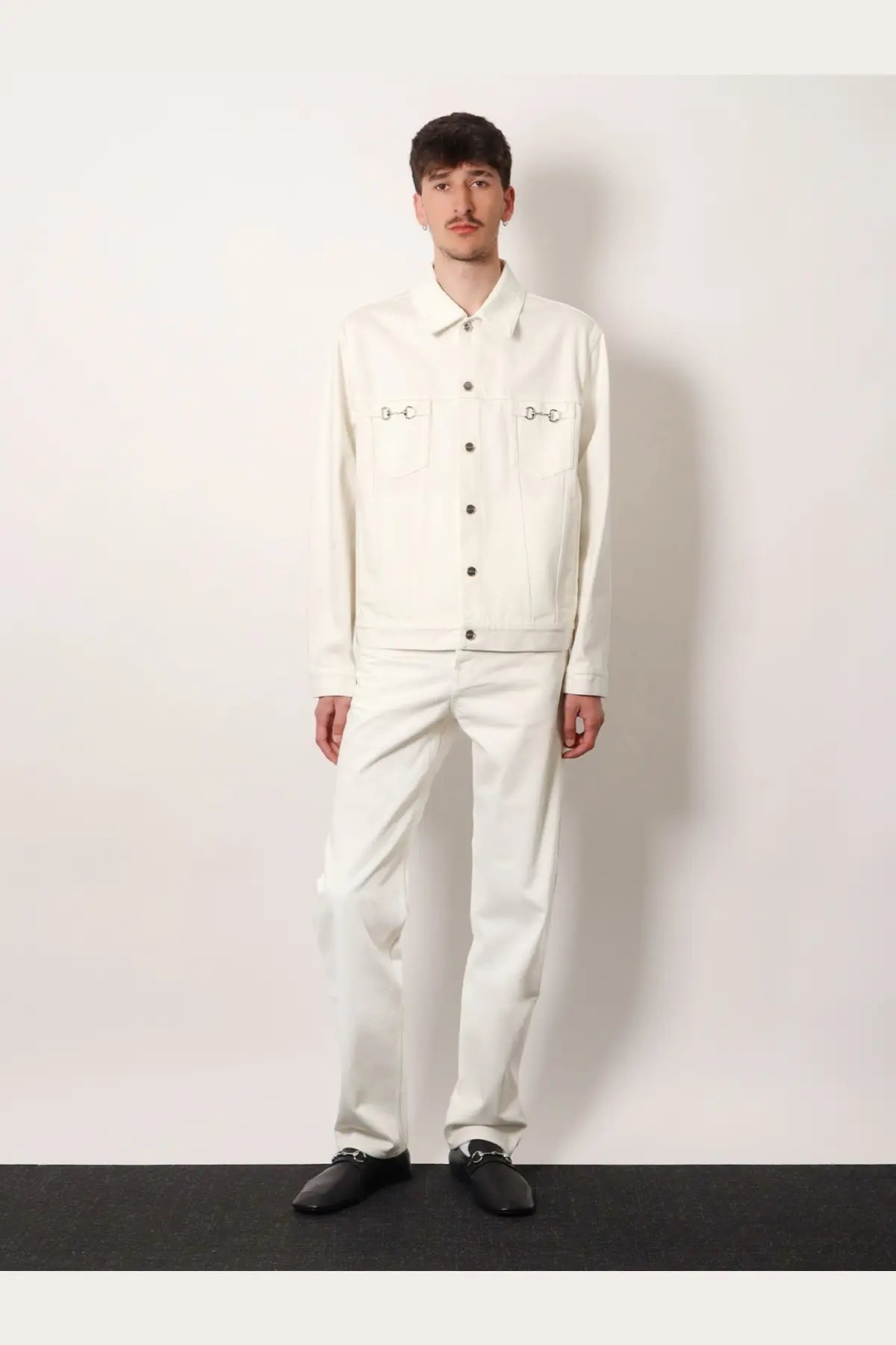 Gucci men’s white denim jacket with black button accents and decorative stitching on chest pockets