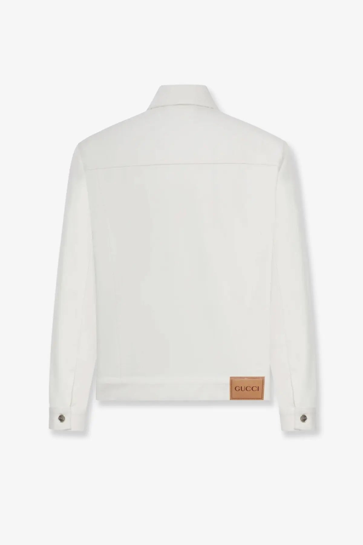 Gucci men’s white denim jacket with a brown leather patch at the bottom hem shown from the back side