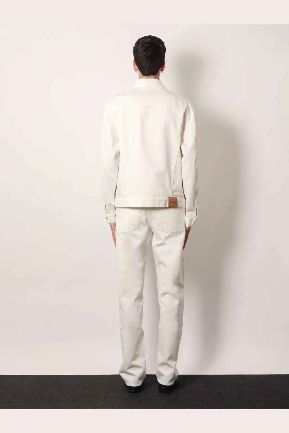 Gucci men’s white denim jacket with a crisp white finish and subtle brown leather patch at the waistband