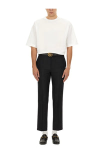 Black gucci belt with gold toned interlocking g buckle paired with gucci men’s wool blend twill pants black