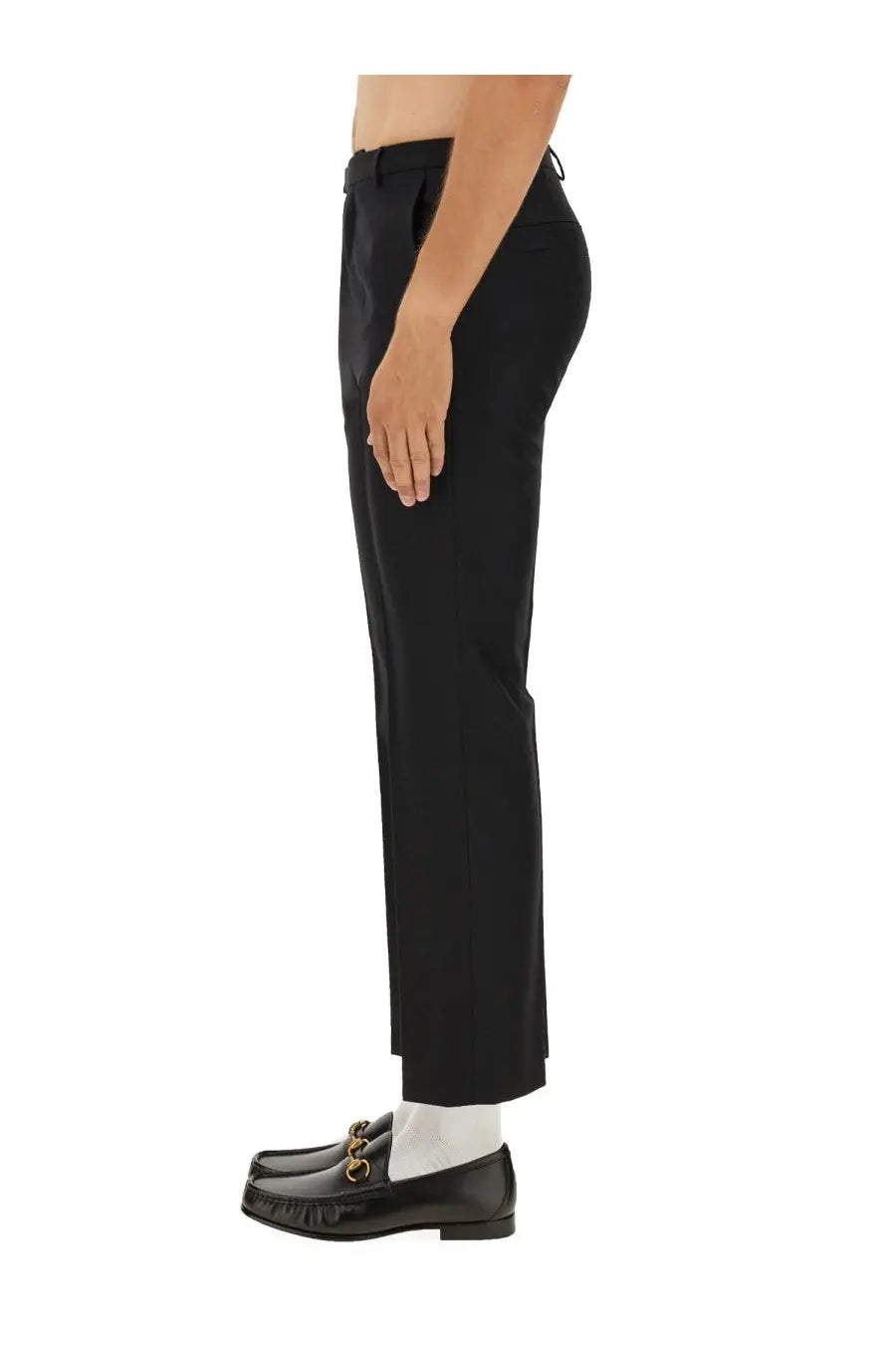 Gucci men’s black wool blend twill pants with straight-leg cut and pleated waistband paired with black leather loafers featuring gold horsebit detailing