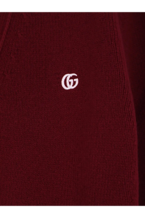 A burgundy knitted gucci men’s wool and cashmere cardigan with a white embroidered gucci logo on the front