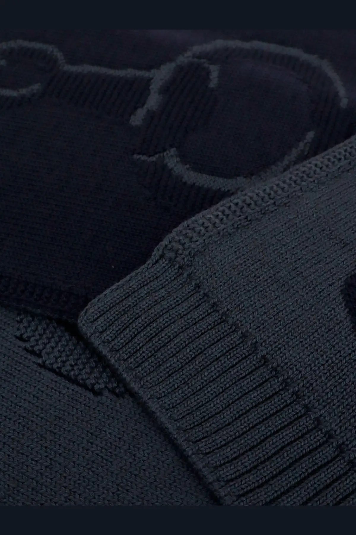Dark navy knit sweater with ribbed cuffs and textured pattern shown with gucci men’s wool scarf graphite
