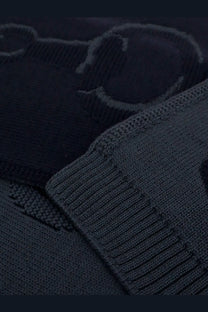 Dark navy knit sweater with ribbed cuffs and textured pattern shown with gucci men’s wool scarf graphite