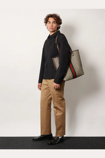 Beige and brown gucci tote bag with red and green striped shoulder strap shown with gucci men’s wool shirt jacket grey