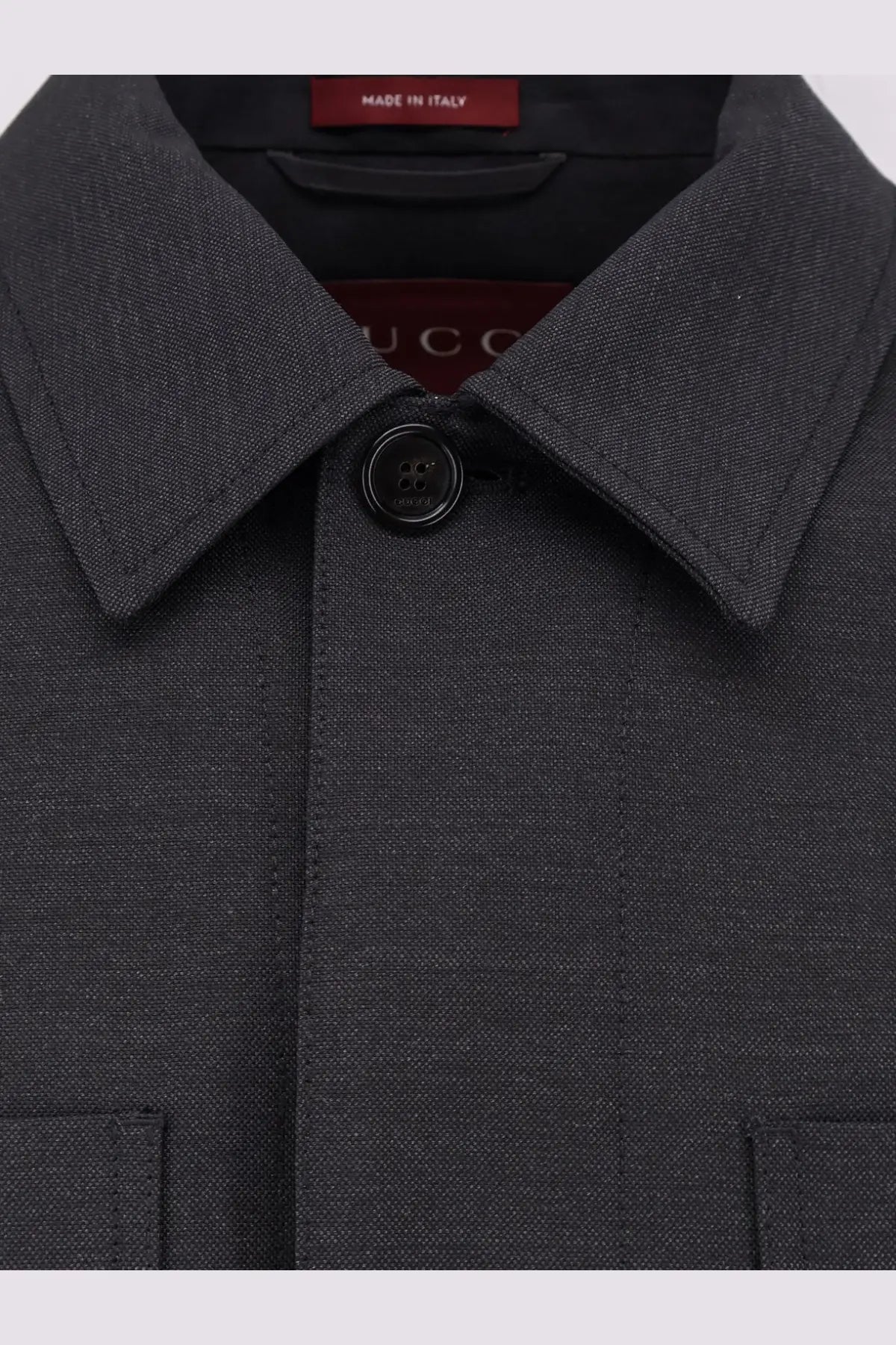 Dark gray textured wool men’s shirt jacket with black buttons and Gucci branding tag in grey color