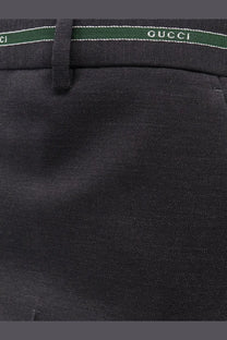 Black Gucci men’s wool trousers with textured weave and contrasting green waistband with white lettering detailing