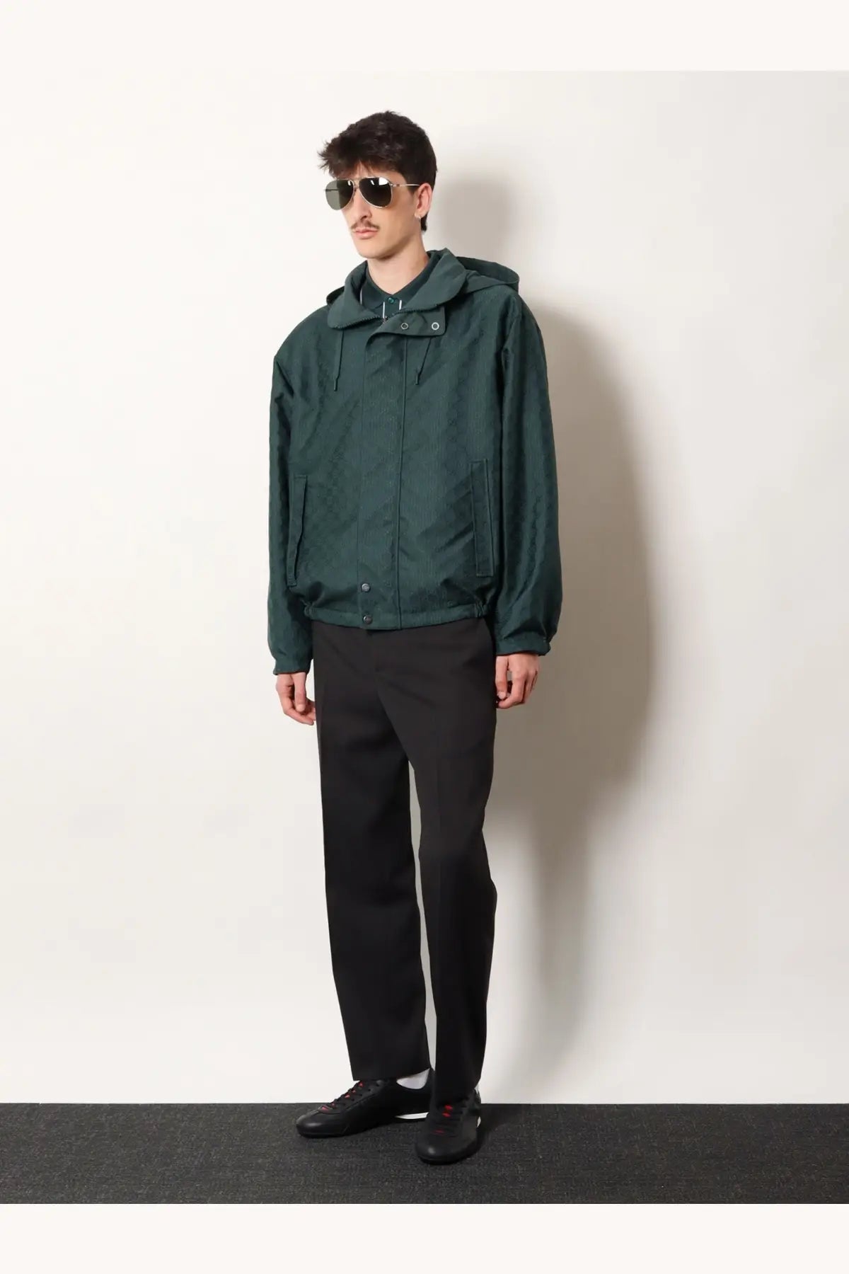 Dark green hooded jacket with subtle textured fabric and front zipper closure paired with gucci men’s wool trousers grey