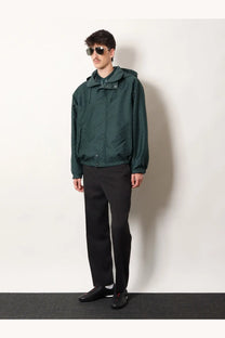 Dark green hooded jacket with subtle textured fabric and front zipper closure paired with gucci men’s wool trousers grey