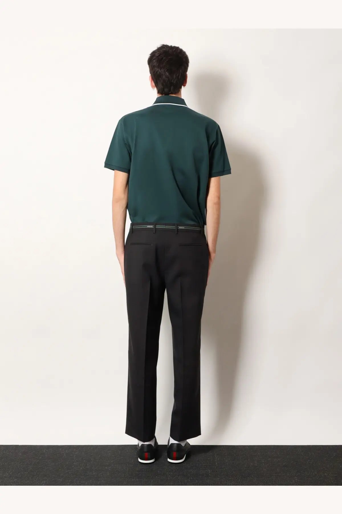Dark green short-sleeved polo shirt with white collar trim paired with gucci men’s grey wool trousers