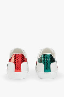 White Gucci women’s Ace leather sneakers with vibrant red and green metallic snake-skin heel tab shown from back