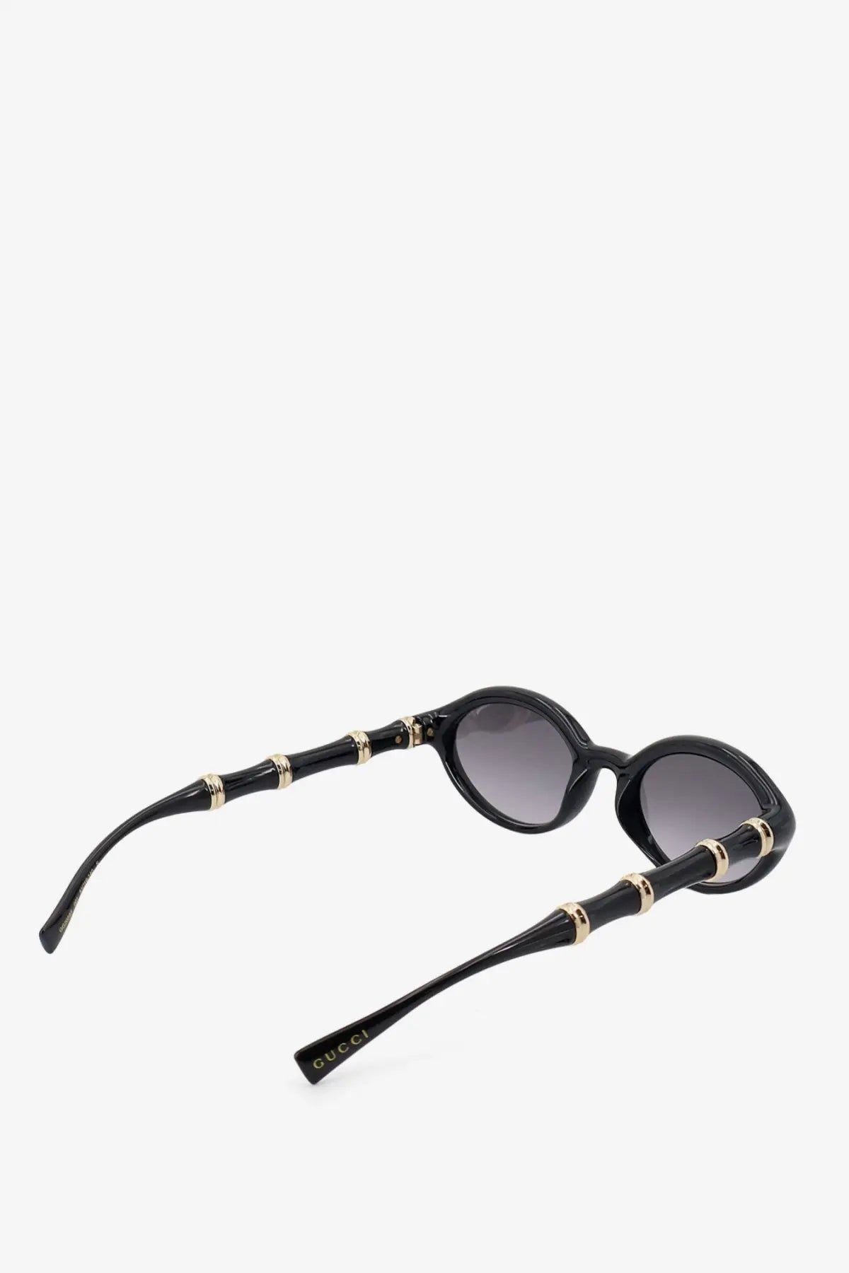 Gucci women’s black acetate sunglasses with bamboo-inspired gold-tone accents and gradient gray lenses