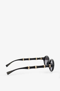 Gucci women’s acetate sunglasses in black with a bamboo pattern gold-tone accents and dark lenses