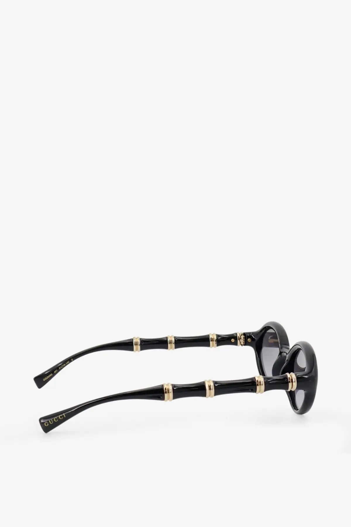 Gucci women’s acetate sunglasses in black with bamboo pattern gold tone accents and dark lenses