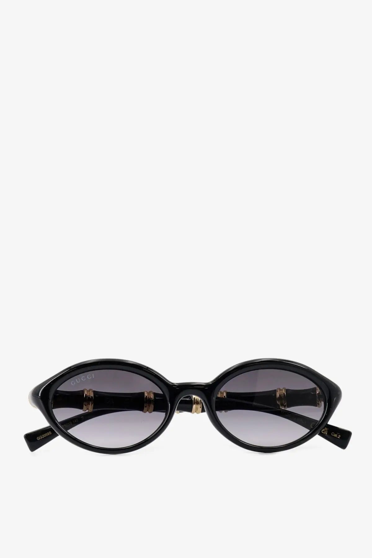 Black Gucci women’s acetate sunglasses with oval shape gold-tone bamboo temples and gradient gray lenses