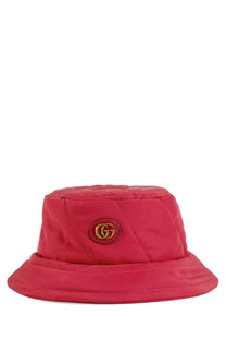 A vibrant red quilted bucket hat with a gold-toned Gucci logo emblem on the front for women