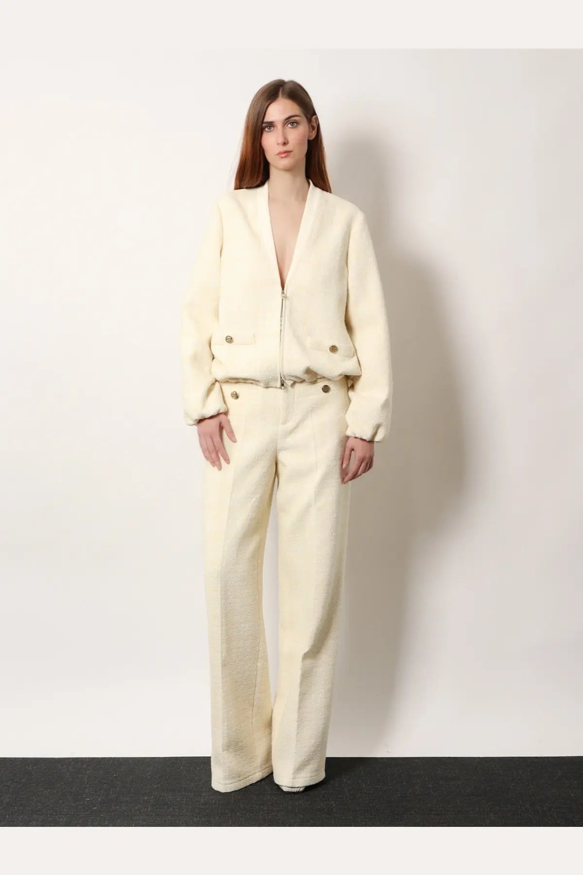 Cream-colored wool blend bomber jacket with front zipper and button accents paired with Gucci white cotton blend trousers