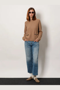Gucci women’s blue cotton jeans paired with a camel-colored ribbed knit sweater featuring front pockets and metal clasps