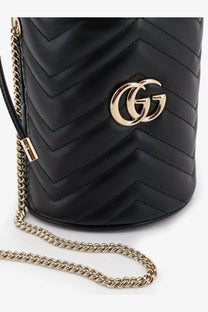 Black quilted leather gucci women’s gg marmont matelassé bucket bag with gold-tone interlocking gg logo and chain strap
