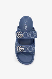 Blue Gucci women’s laser GG denim slide sandals featuring double GG logo buckles and a denim-like pattern