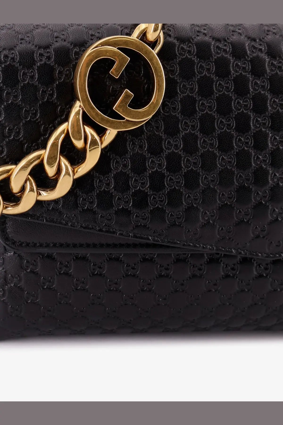 Black gucci women’s leather crossbody bag with glossy embossed gg monogram and gold-tone chain strap featuring interlocking g logo