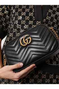 Black quilted leather Gucci Marmont camera bag with gold-tone gg logo and chain strap for women crossbody use
