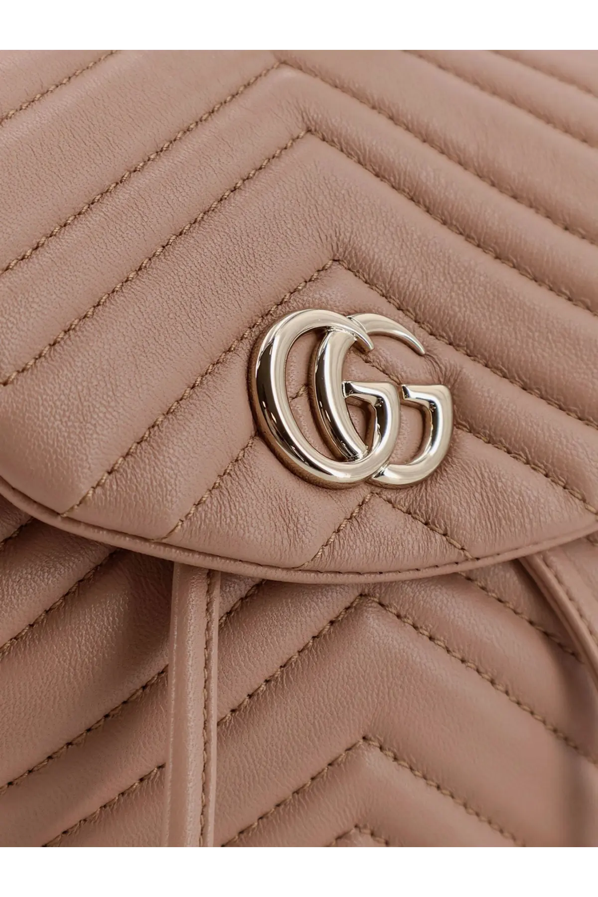 Beige quilted leather Gucci women’s mini GG Marmont backpack with gold tone interlocking GG logo clasp