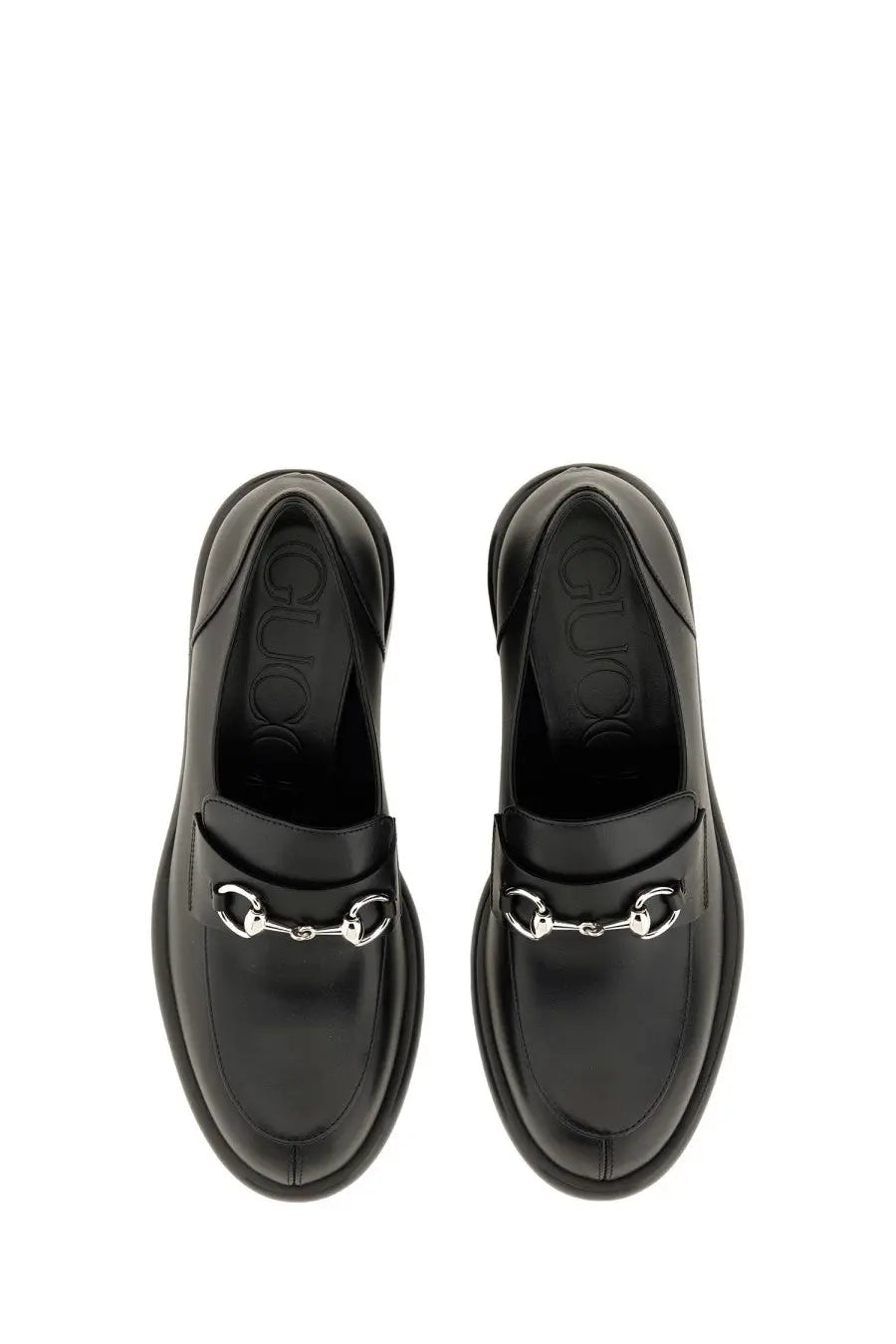 Black Gucci women’s moccasin loafers with glossy leather finish and signature silver horsebit buckle