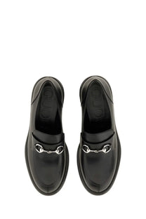 Black Gucci women’s moccasin loafers with glossy leather finish and signature silver horsebit buckle