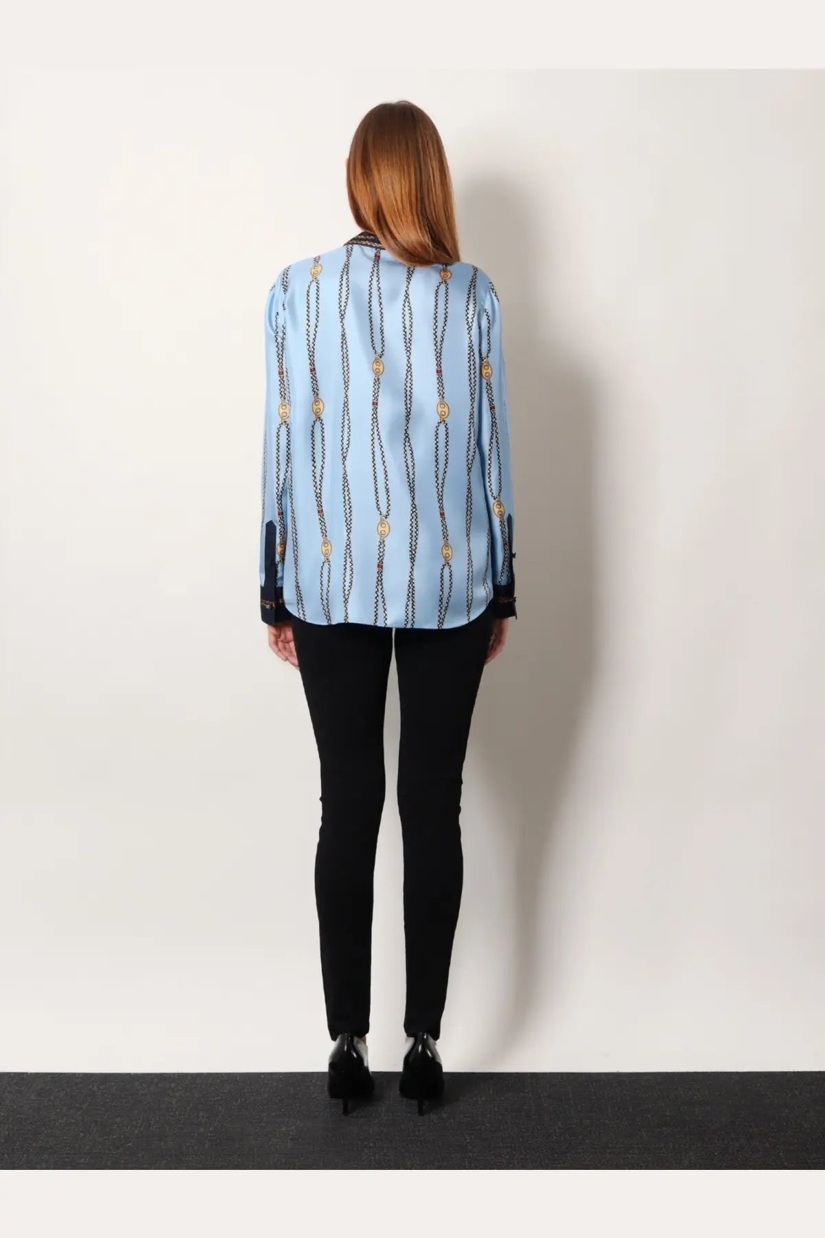 Light blue gucci women’s printed silk twill blouse with vertical chain and gold-tone medallion pattern and black cuffs