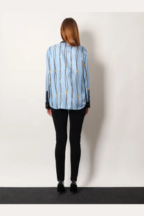 Light blue gucci women’s printed silk twill blouse with vertical chain and gold-tone medallion pattern and black cuffs