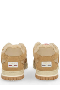 Tan suede Gucci women’s RE Web sneaker with plush white shearling lining and beige rubber sole front view