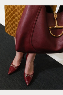 Gucci women’s Rosso Ancora red patent leather pumps with pointed toe and gold-tone horsebit detailing