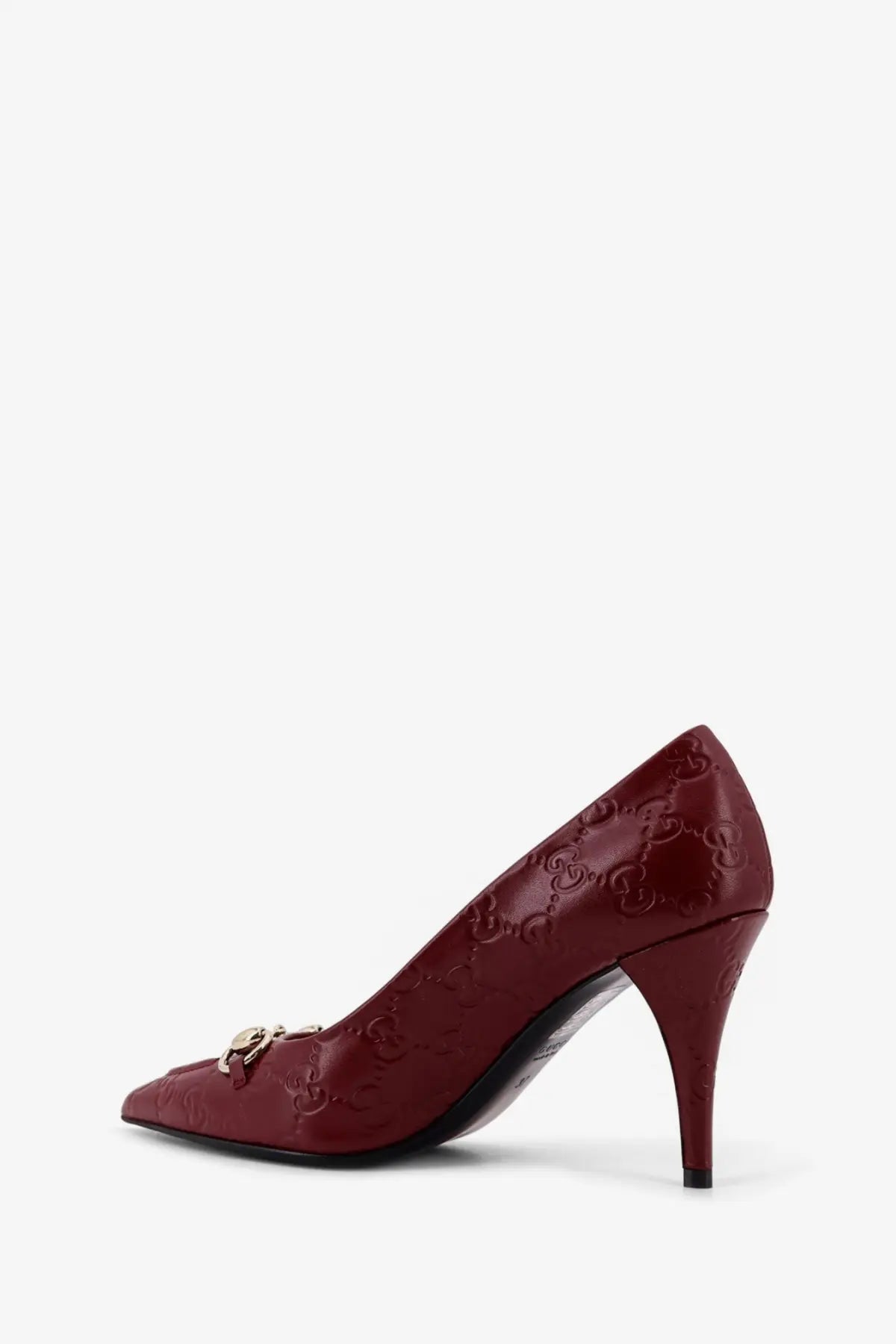 Burgundy Gucci women’s Rosso Ancora GG leather pump with embossed monogram and gold-tone horsebit detail at the toe