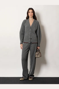 Gray ribbed knit cardigan with dark buttons and red trim paired with gucci women’s stretch wool trousers grey