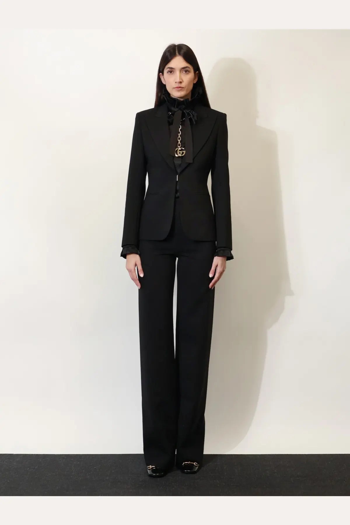 Gucci women’s black technical wool blazer with tailored fit bow tie and gold-tone Gucci logo pendant accessory