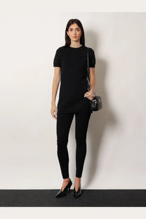 Black quilted leather Gucci crossbody bag with small bow detail shown with womens viscose blend leggings black
