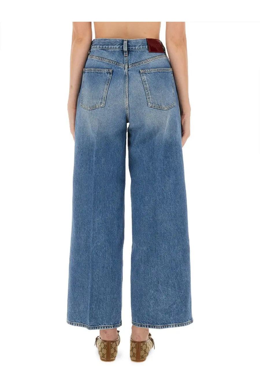 Back view of gucci women’s high-waisted wide-leg denim trousers in medium blue wash with subtle fade and classic pockets
