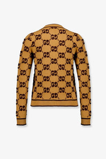 Back view of a mustard-yellow gucci women’s wool cardigan with black gg monogram pattern ribbed cuffs and hem