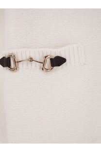 A sleek metallic horsebit clasp with dark brown leather tabs on a Gucci women’s white wool and cashmere cardigan
